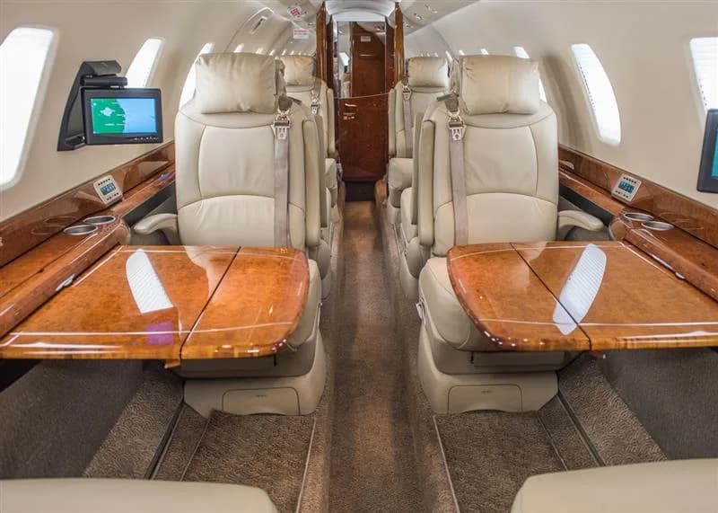 The aircraft's interior features leather seats and wood accents.
