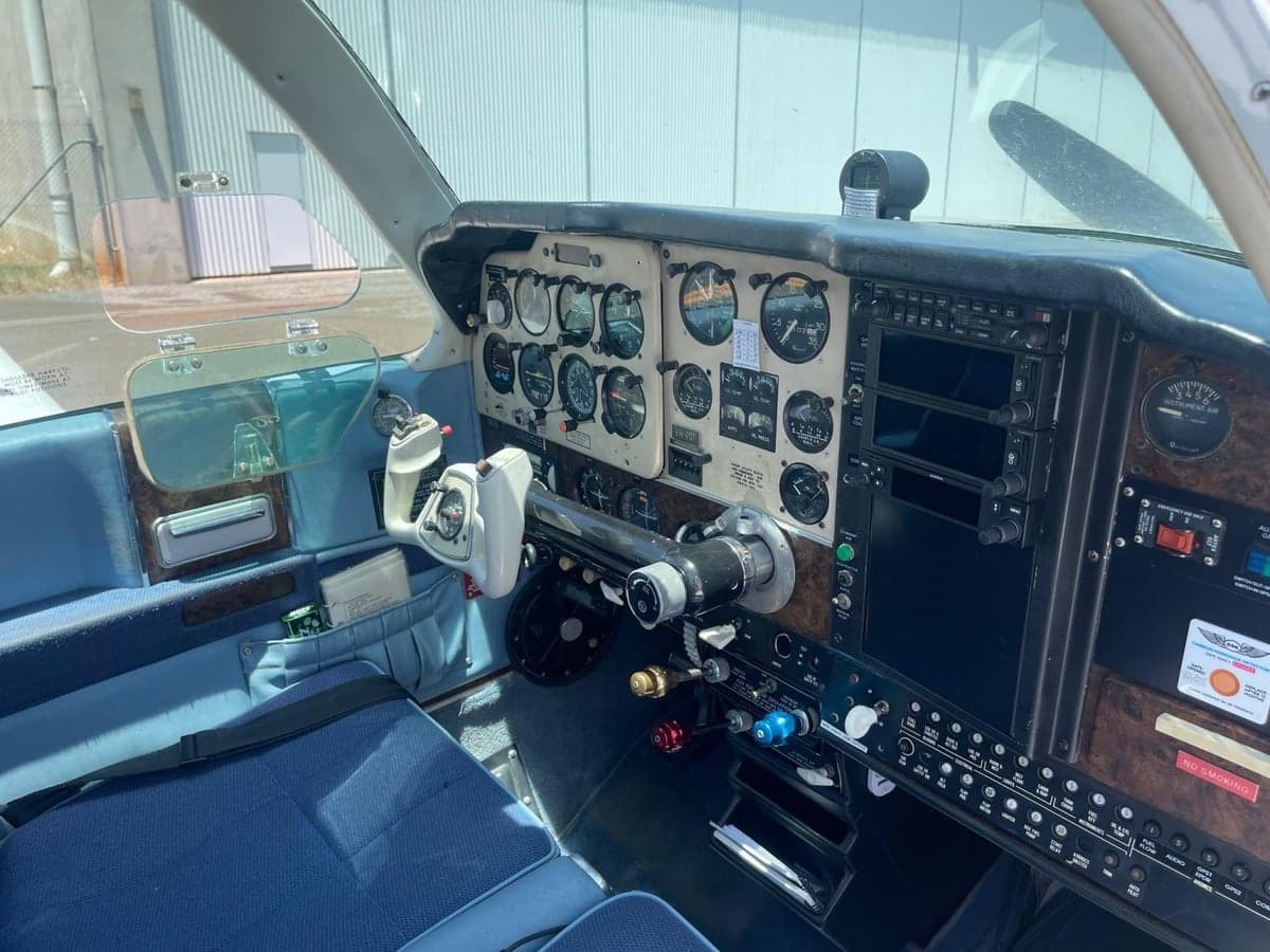 The cockpit of a light aircraft with a blue interior, showing the instrument panel and yoke.