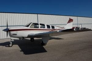 A Beechcraft Bonanza sits on the tarmac.