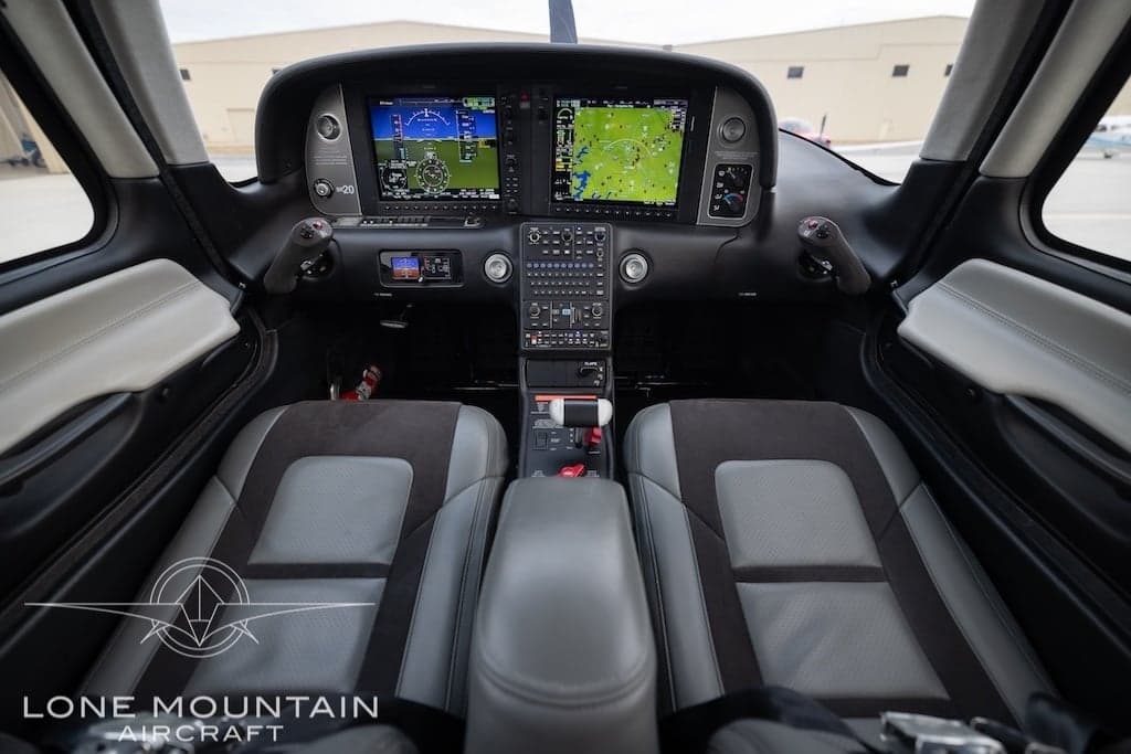 The cockpit of a Cirrus SR22T aircraft features a modern glass panel and comfortable seats.