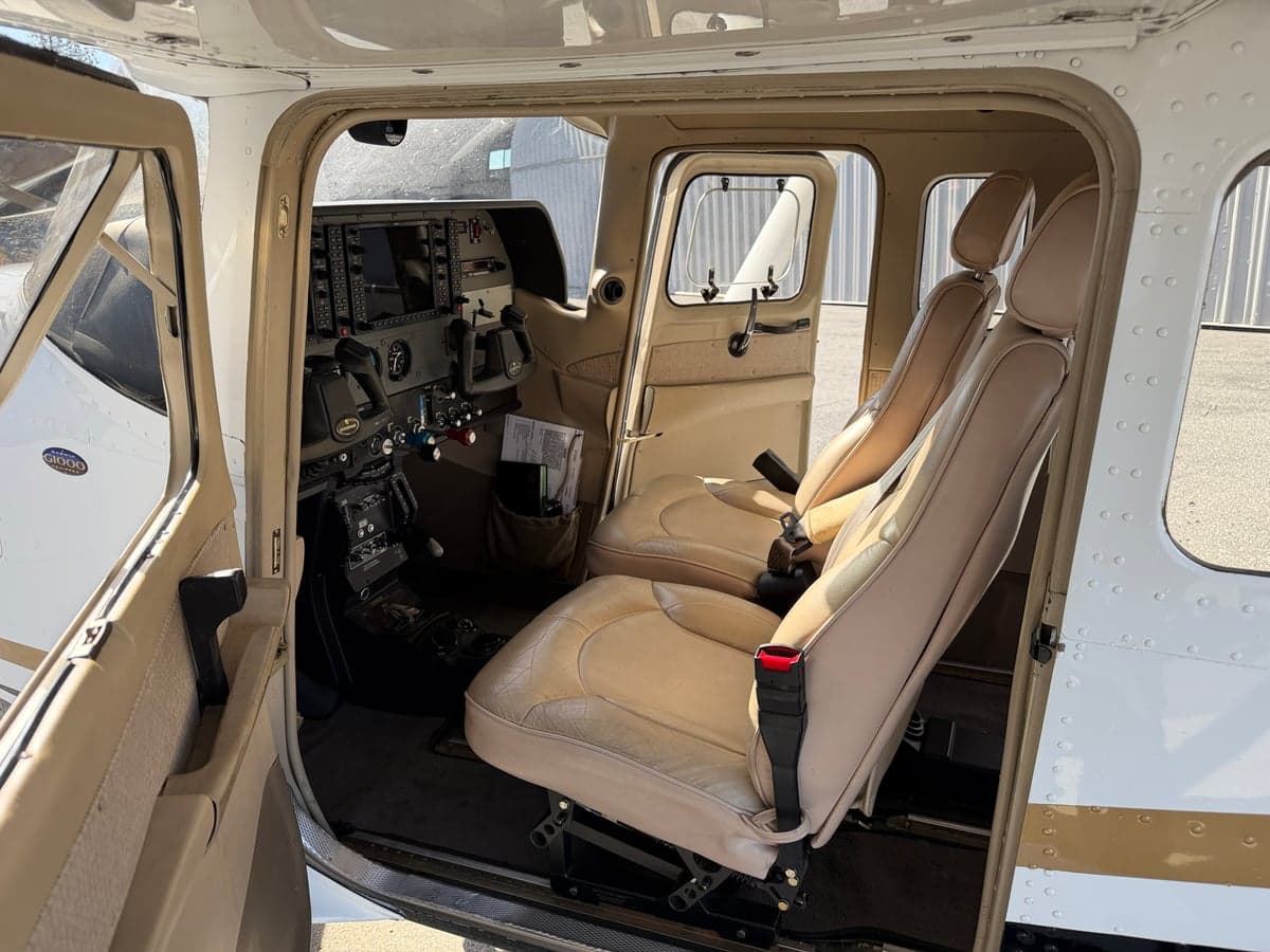 View of the aircraft's front seats and cockpit from the open cabin door.