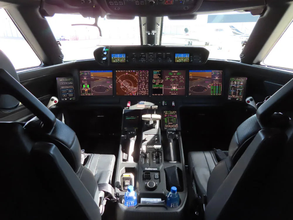The cockpit of a Gulfstream G500 with multiple display screens.