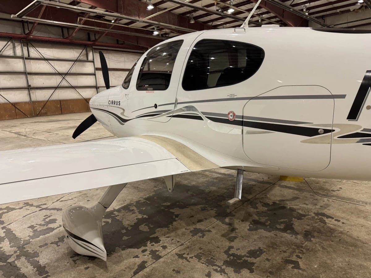Close-up side view of a Cirrus SR22T, highlighting the paint scheme and landing gear.