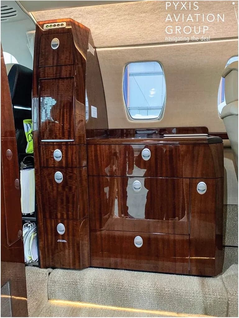 The aircraft's interior features a wooden cabinet.