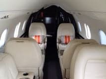 View of the aircraft's interior with four seats and striped pillows.