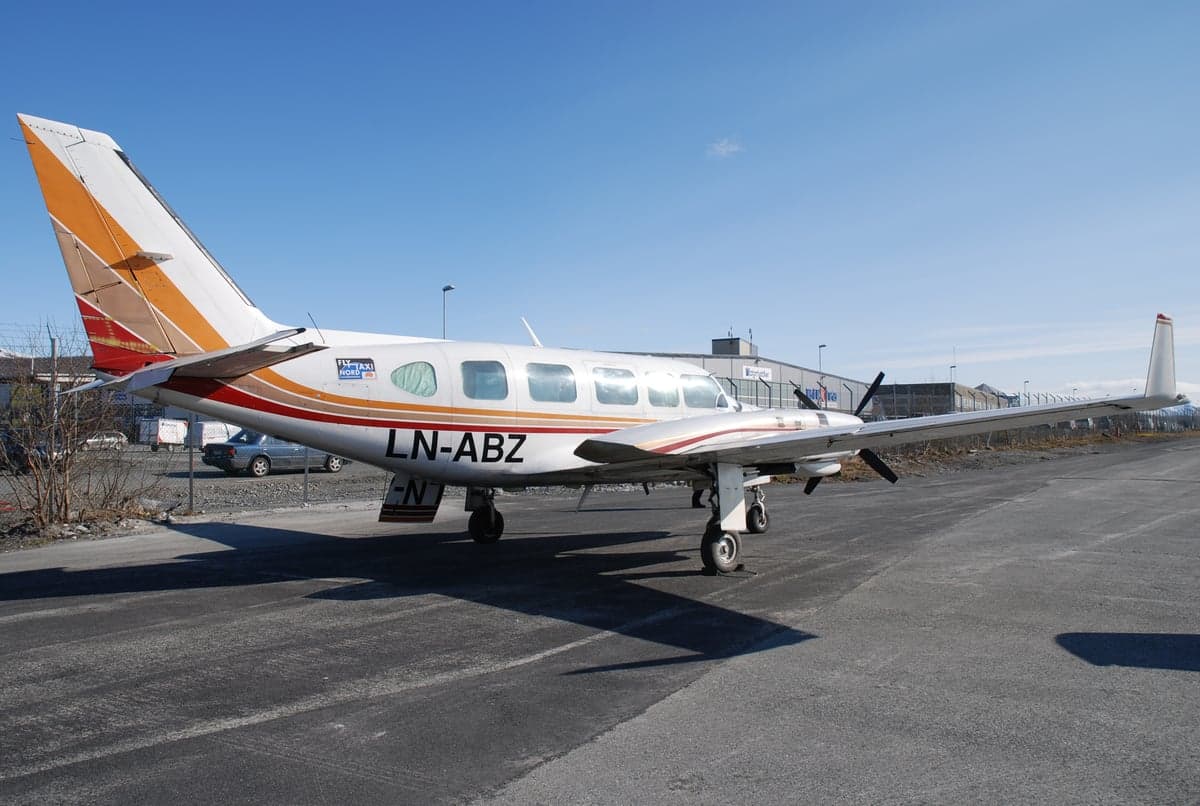 A Piper PA-31 Navajo aircraft is parked on the tarmac.