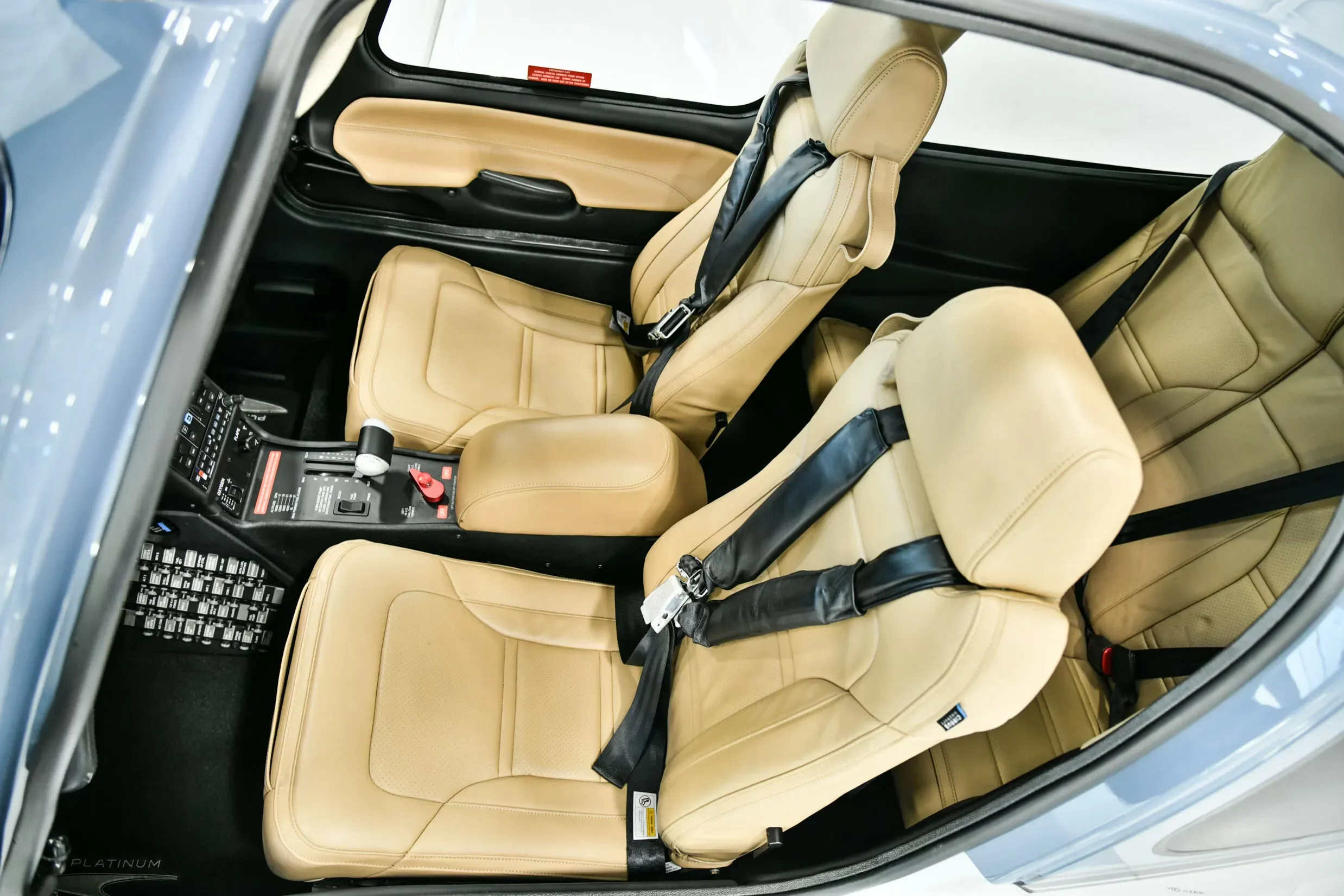 The tan leather front seats of a Cirrus SR22 aircraft cabin, viewed from above and to the side.
