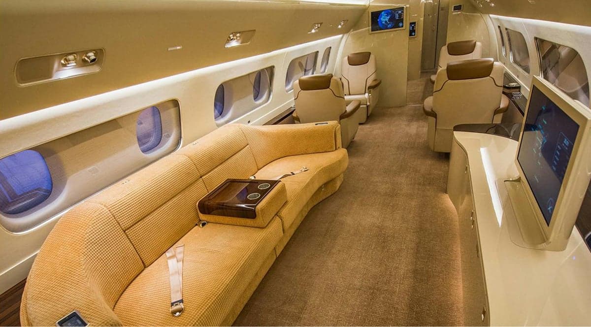 A view of the aircraft's interior, featuring a tan couch and a television screen.