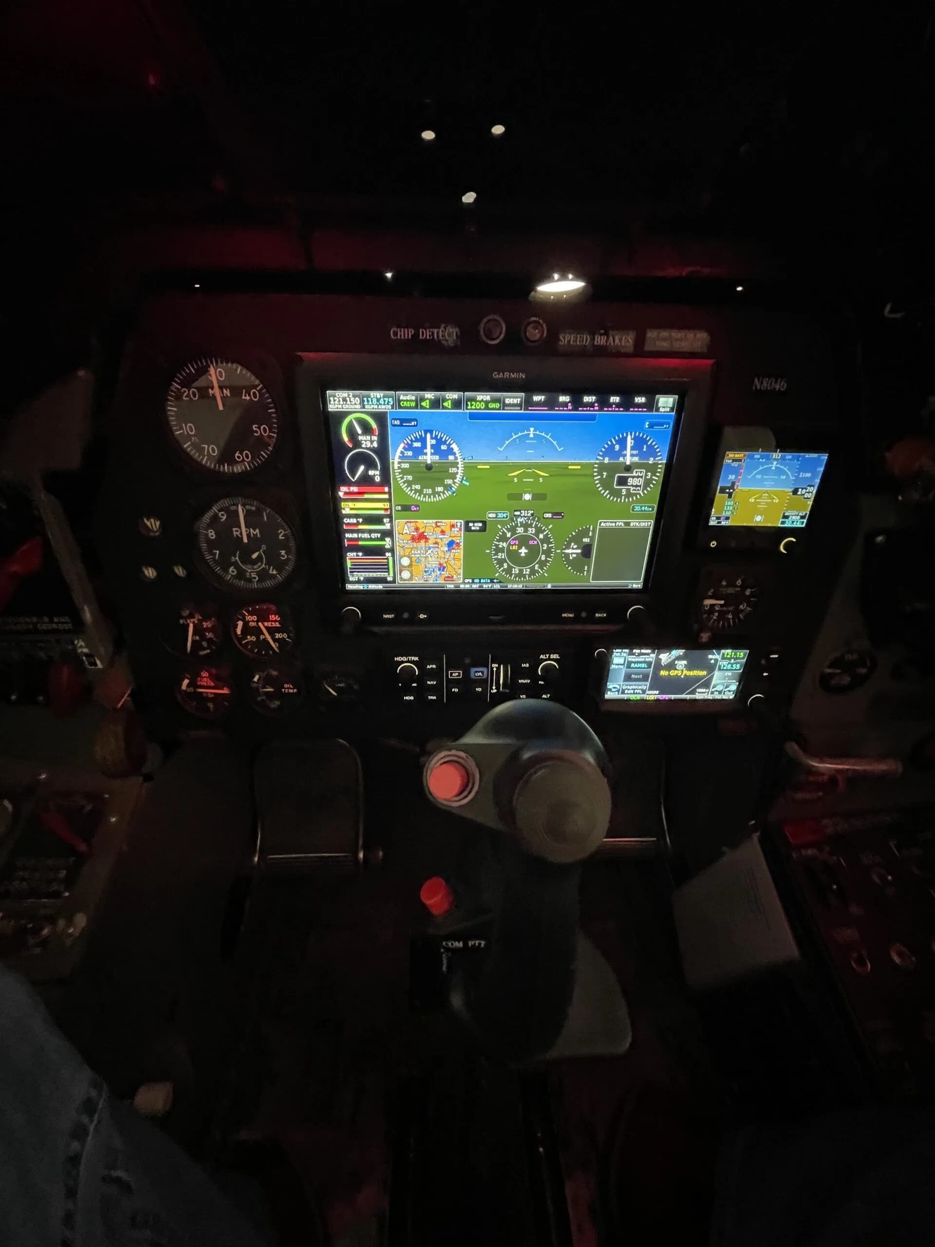The T-28 Trojan's cockpit instrument panel, featuring a central digital display, various gauges, and the control stick.