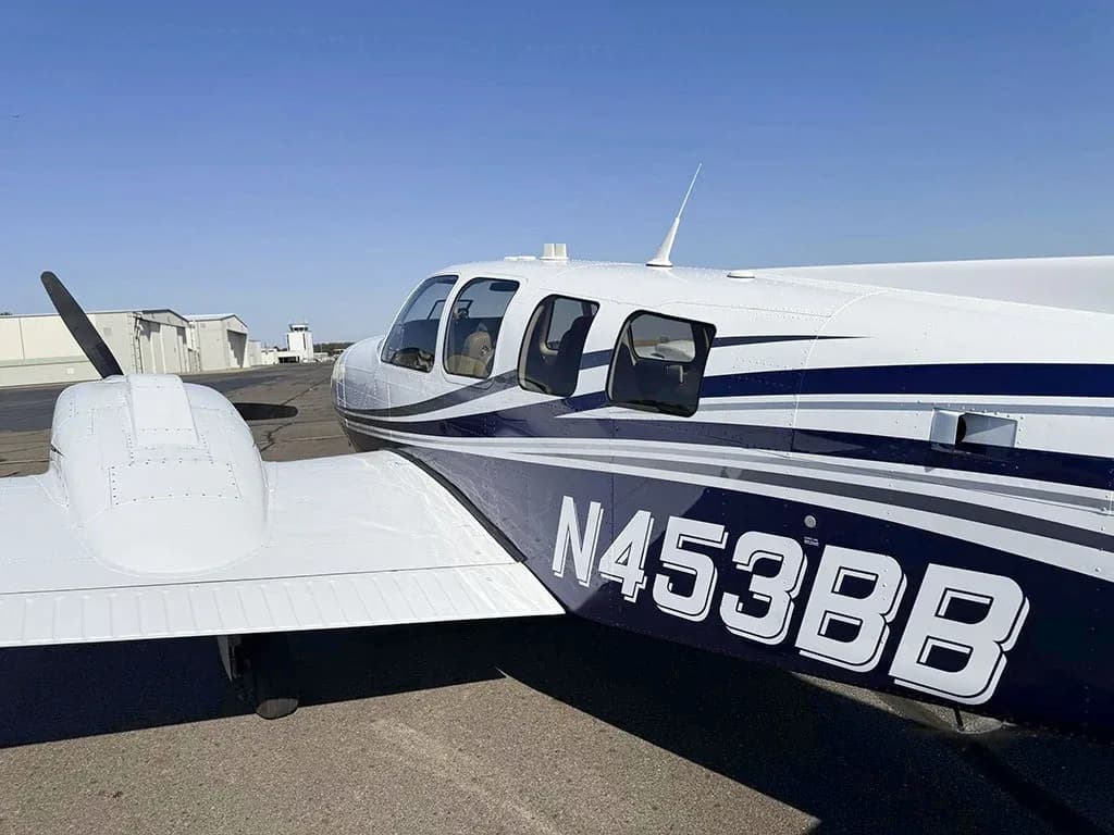A close-up view of the fuselage of Beechcraft Baron N453BB, showing the white and blue paint scheme.