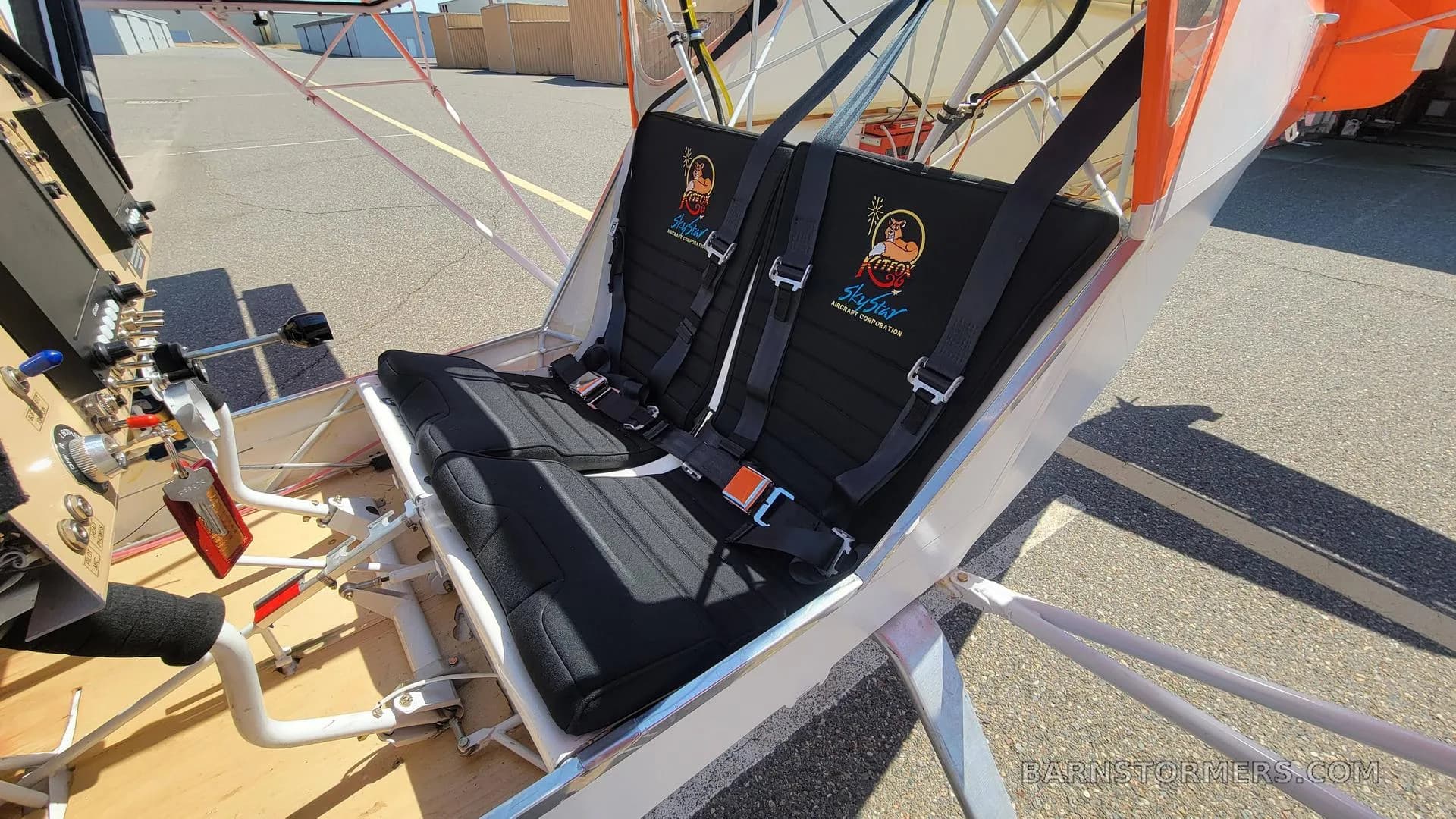 The two black fabric seats with harnesses inside the aircraft, featuring 'AirFirst' logos on the headrests.