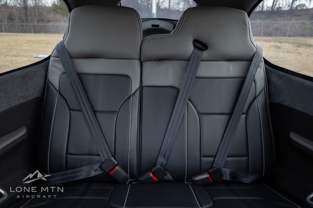 Front seats of a Cirrus SR22T with black leather and gray headrests.