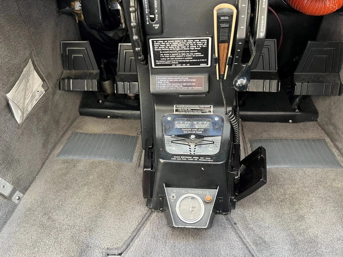View of the aircraft's cockpit floor, rudder pedals, and lower central console with controls and gauges.