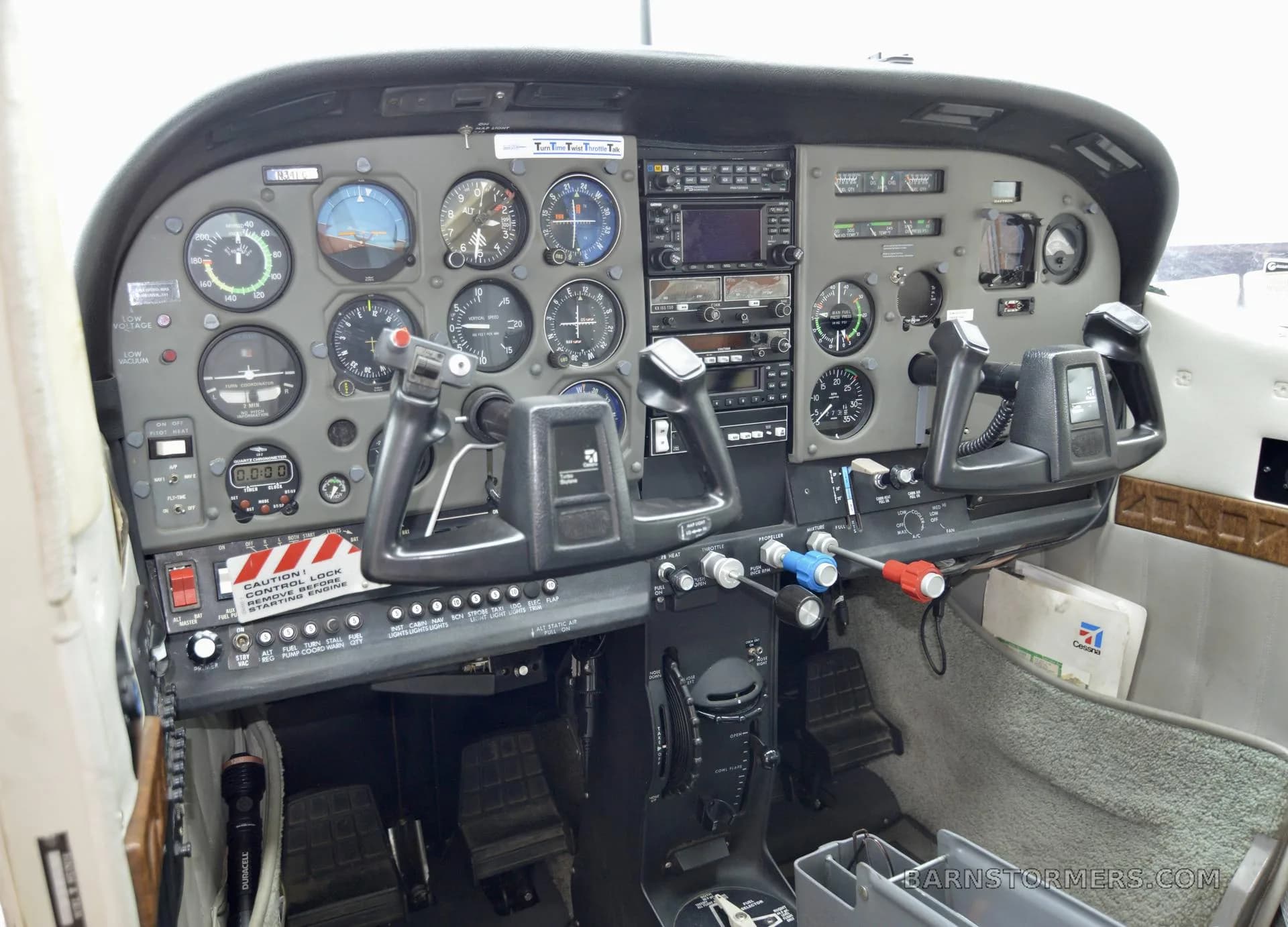 The cockpit of a Cessna 182 Skylane, showing the instrument panel with analog gauges and dual yokes.