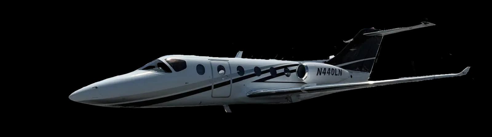Side view of a gray and black jet with registration N440LN against a black background.