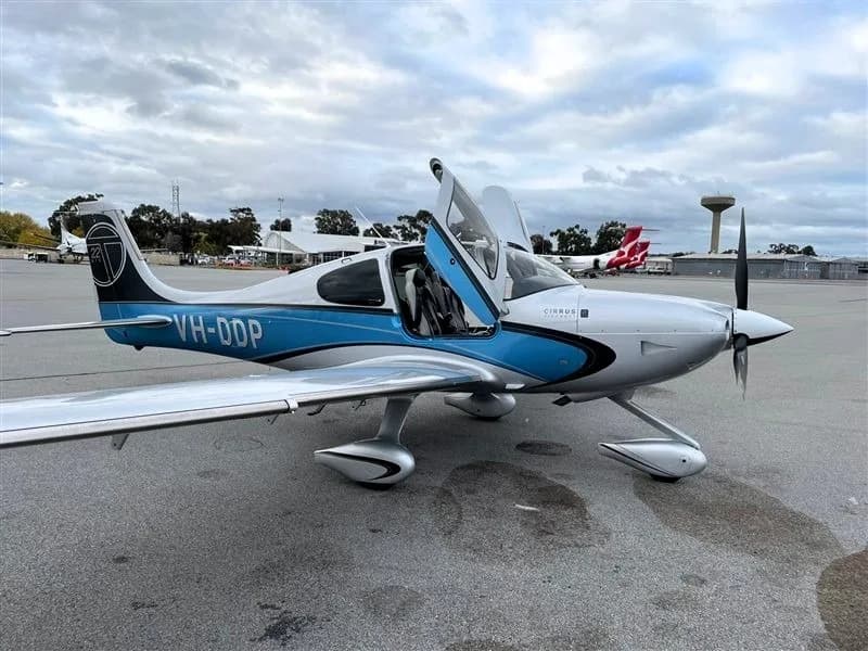 Cirrus SR22 with doors open on the tarmac with a silver and blue paint scheme.