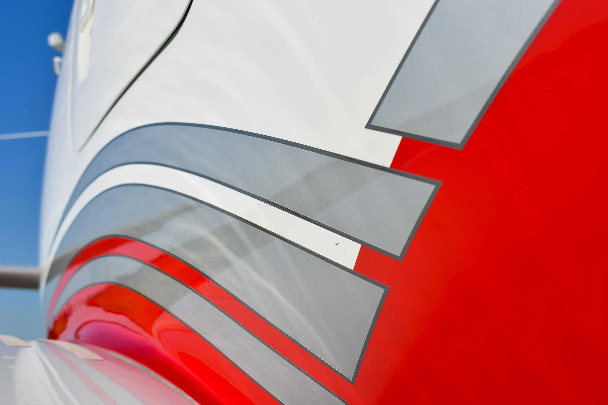 A close-up view of the red, white, and gray stripe paint scheme on the fuselage of the aircraft.