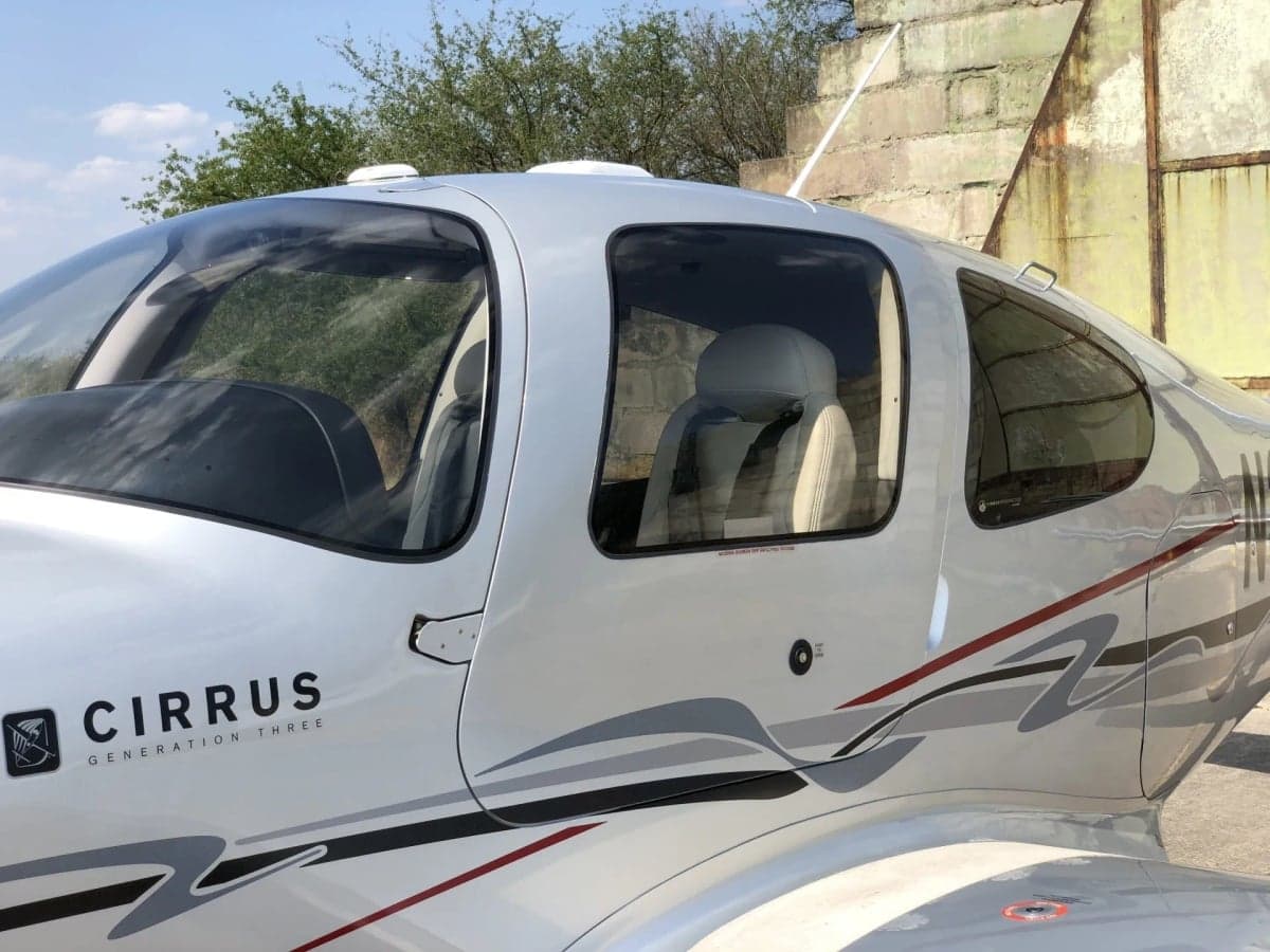 Side view of the Cirrus SR22T with registration N338CP parked on the tarmac.