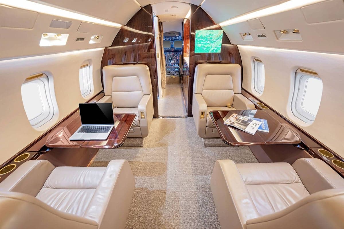 Interior view of the aircraft cabin with seating and tables.