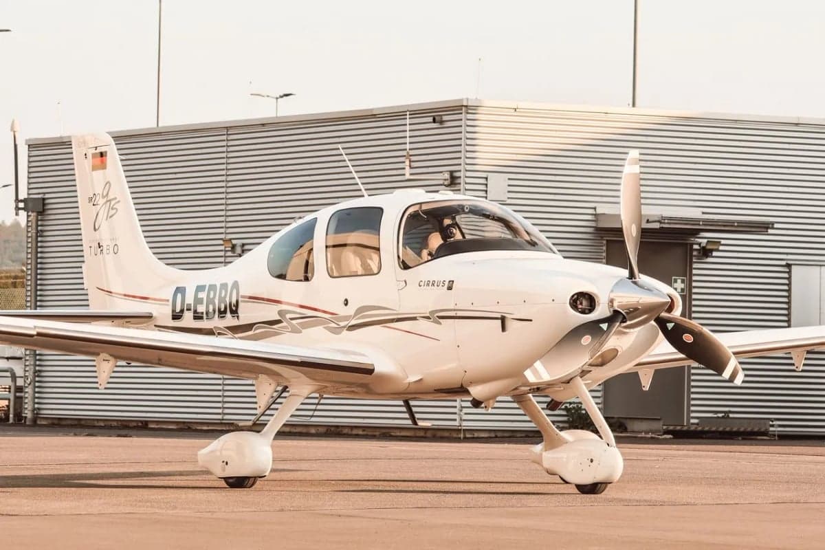 A Cirrus aircraft with registration D-EBBQ parked on the tarmac.