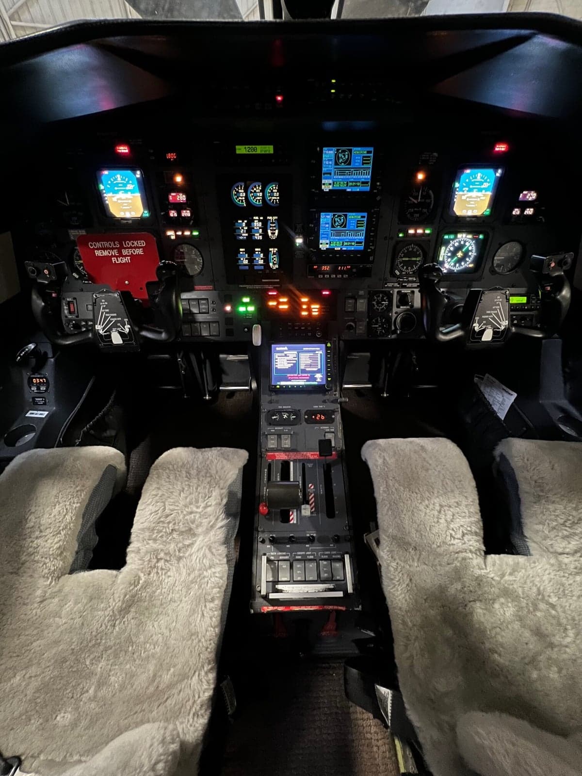 The cockpit of the aircraft features a full glass panel and sheepskin seat covers.