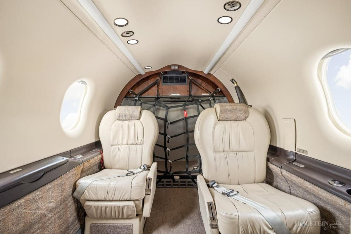 Rear view of the Pilatus PC-12 cabin with leather seats and cargo netting.