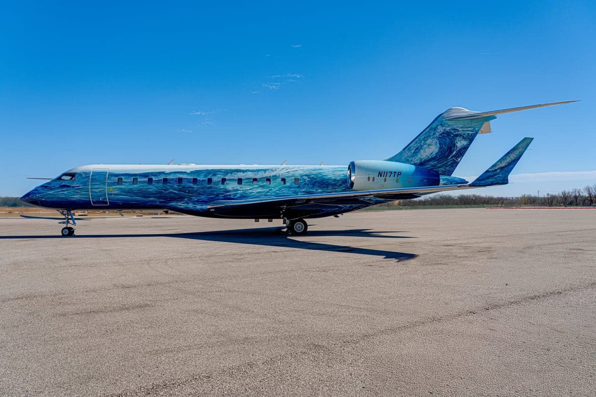 A Bombardier Global Express with a custom ocean wave paint scheme on the ramp.
