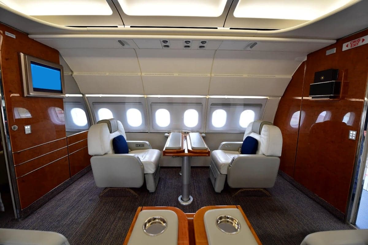 Interior of the aircraft with white seats and a table.