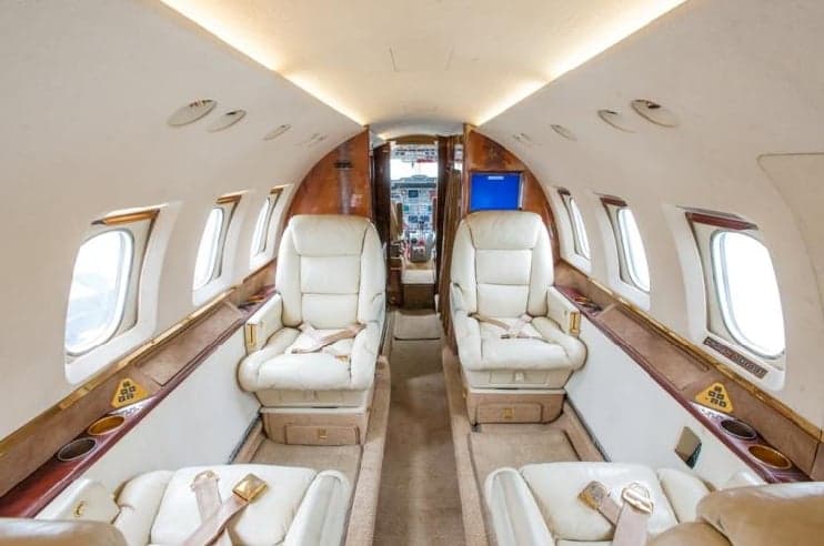 The interior of the aircraft features cream-colored leather seats.