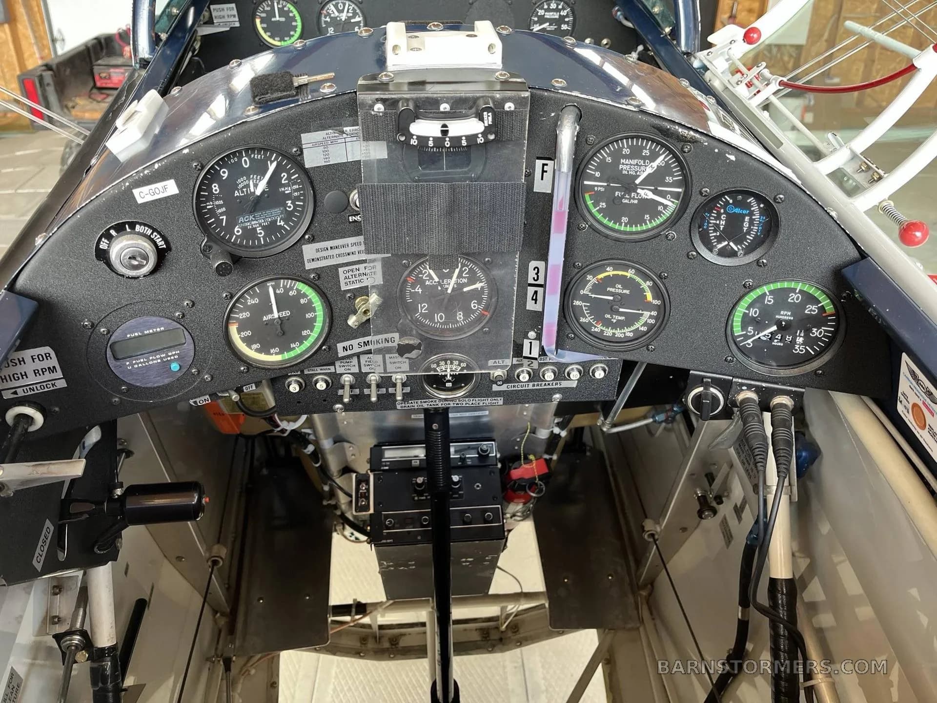 The instrument panel of a biplane cockpit, featuring various gauges and controls.