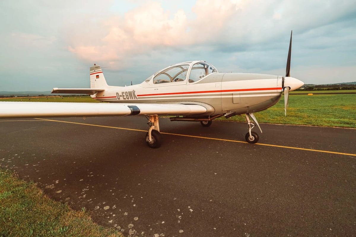 The D-EGWK aircraft is parked on the runway with a gray and white paint scheme.