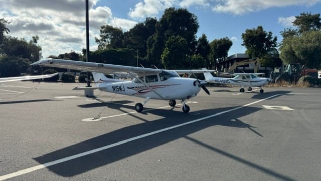 Cessna 172 Skyhawk N15MJ parked on the tarmac with other aircraft.