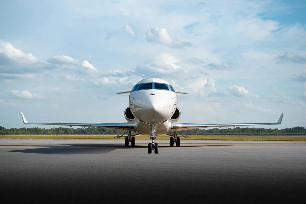 A head-on view of a white Bombardier Global 7500 business jet parked on a tarmac.
