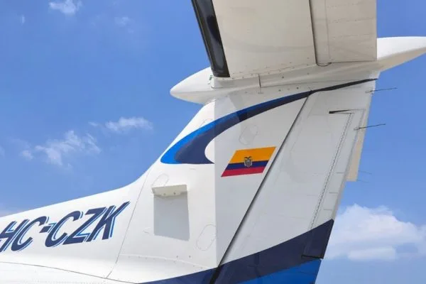 A close-up view of the tail of a white and blue Pilatus PC-12 aircraft, showing the registration HC-CZK and the Ecuadorian flag.