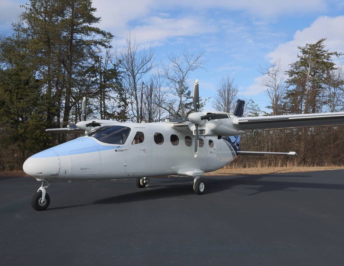 Three-quarter view of a white and blue Tecnam P2012 Traveller aircraft on the ground.