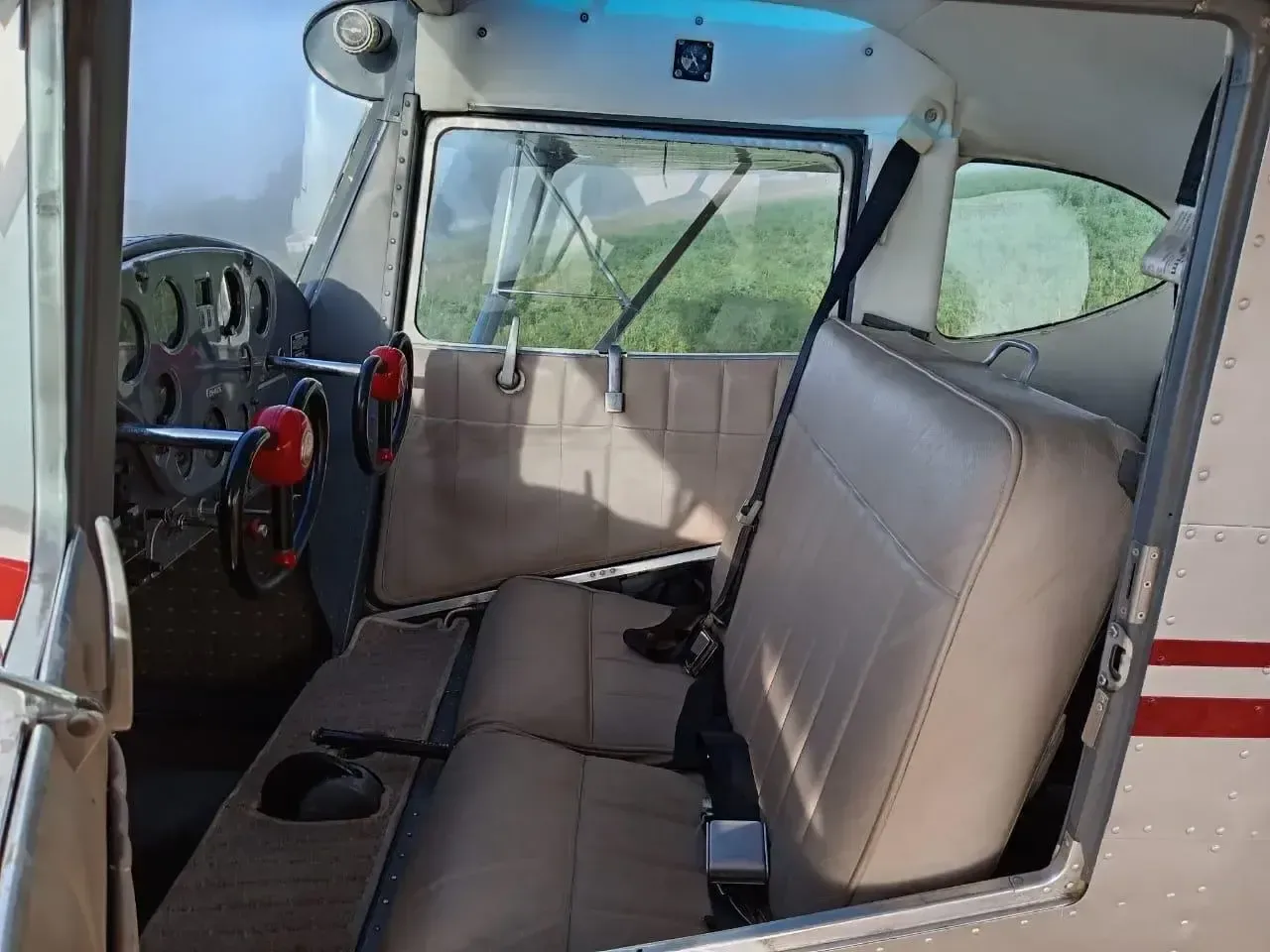 The interior of a Cessna 170 aircraft, showing the seats and side panel.