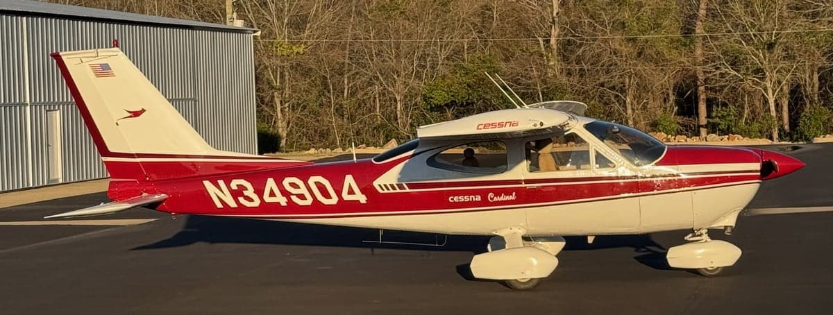A Cessna Cardinal aircraft with tail number N34904 is parked outside a hangar.