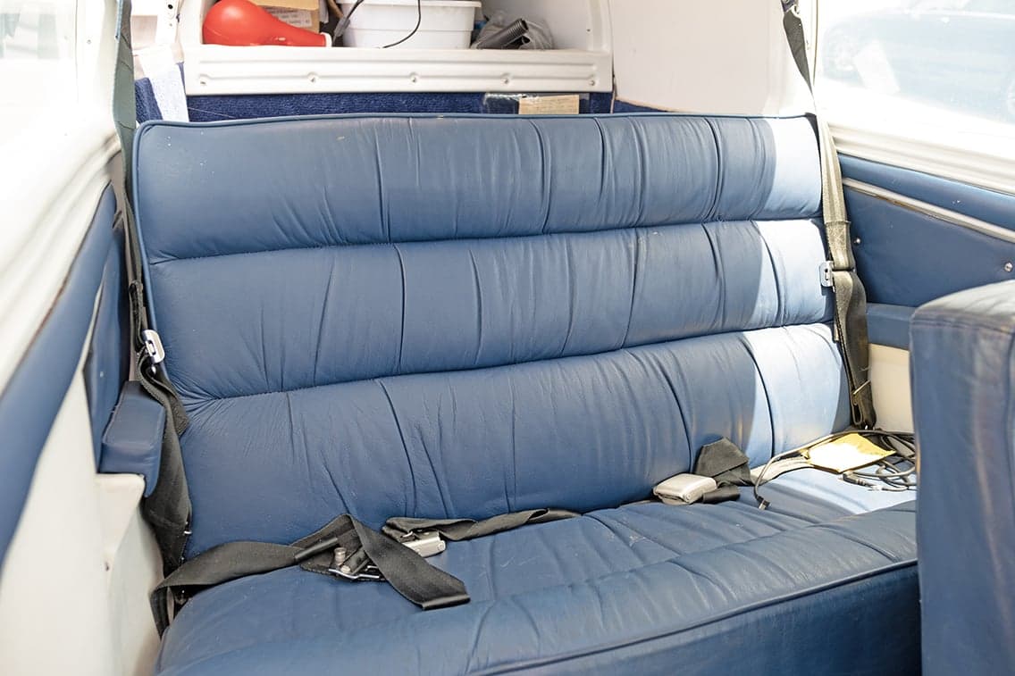 Rear blue leather bench seat of the aircraft interior.