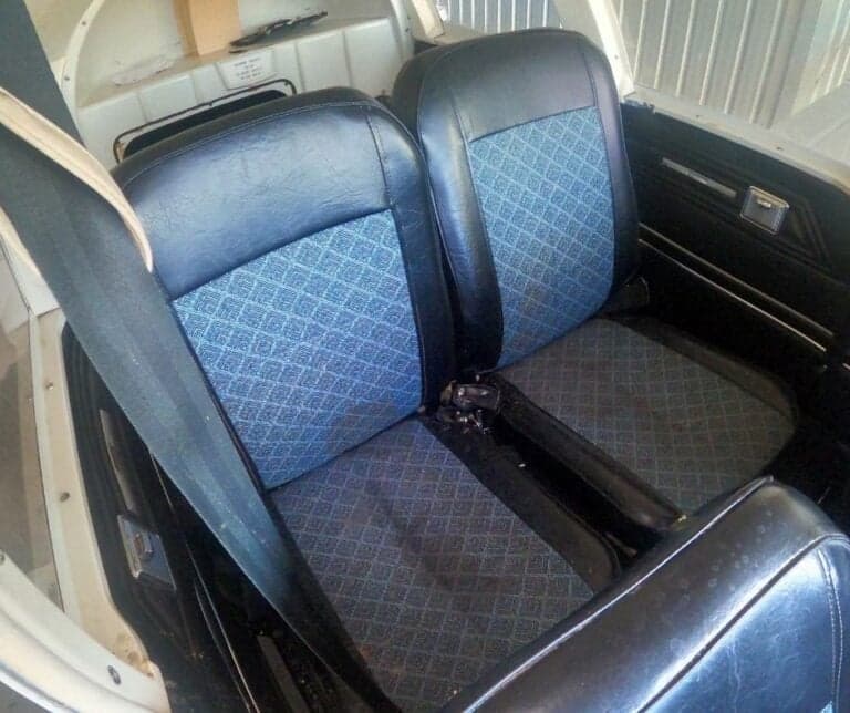 Interior view of the front seats of an aircraft with blue patterned inserts.