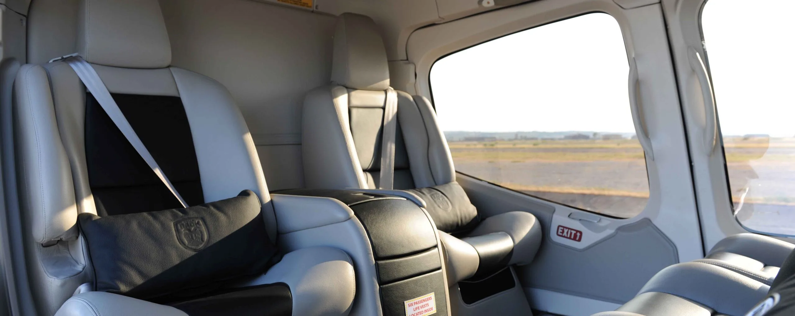 The interior of a helicopter with gray leather seats.