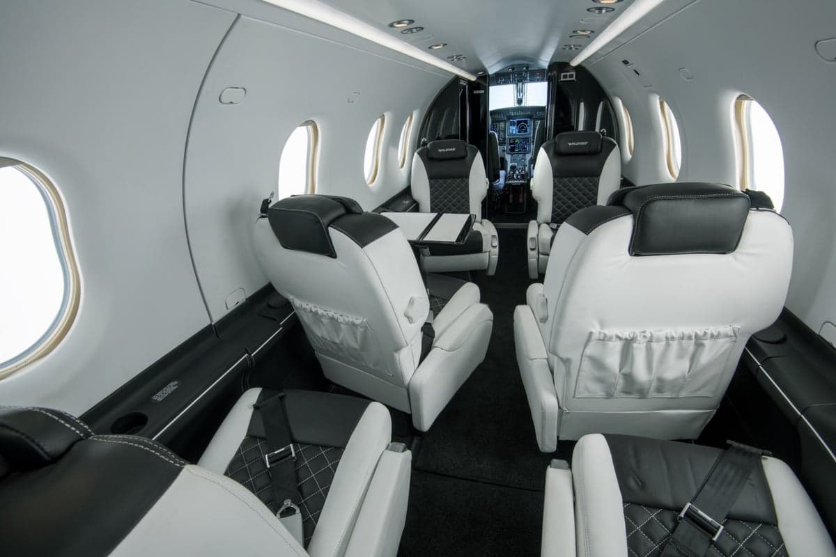 Spacious interior of a Pilatus PC-24 with comfortable seating and a table.