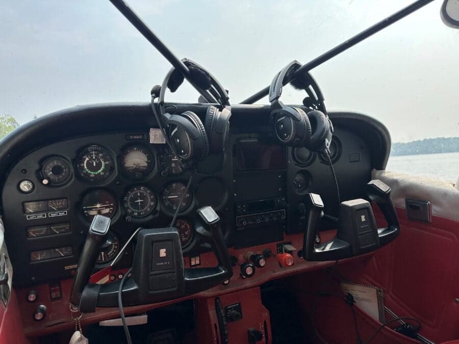 The cockpit of the Cessna floatplane features a full instrument panel and control yokes with headsets.