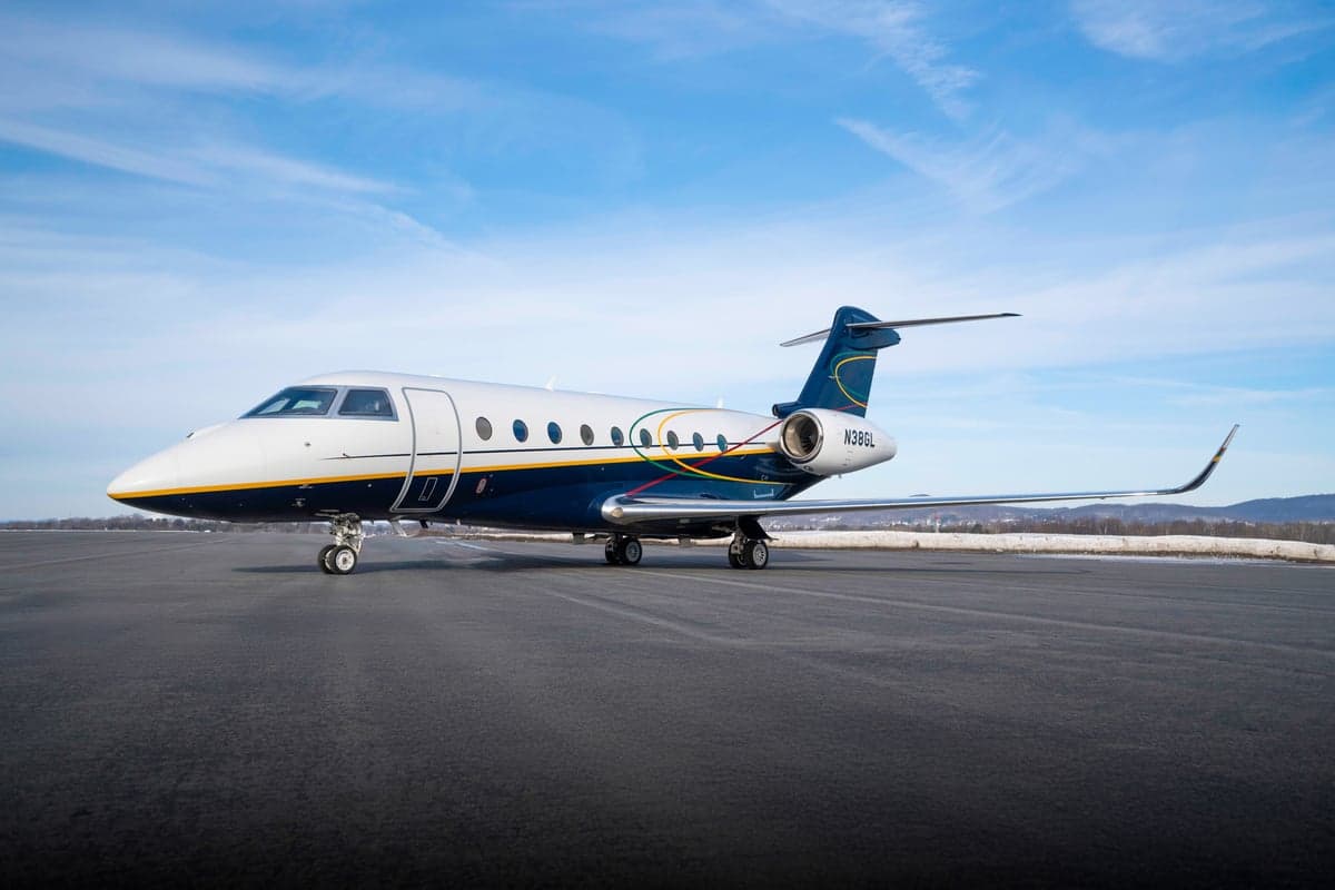 Gulfstream jet N386GL parked on a runway with a blue sky background.