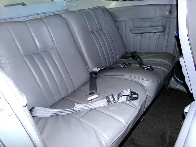 The gray leather rear bench seat with seatbelts in the cabin of a Cessna 182.