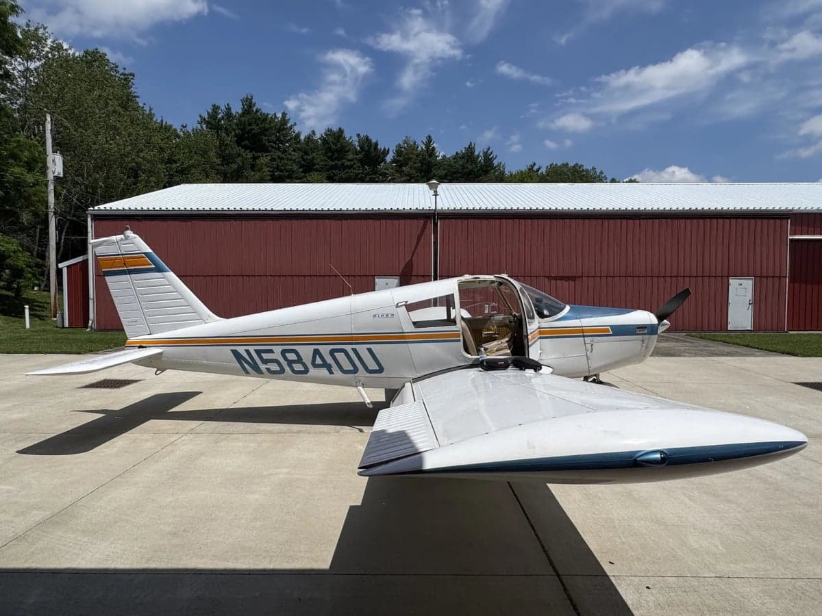 A Piper aircraft with tail number N5840U parked on the tarmac with the door open.