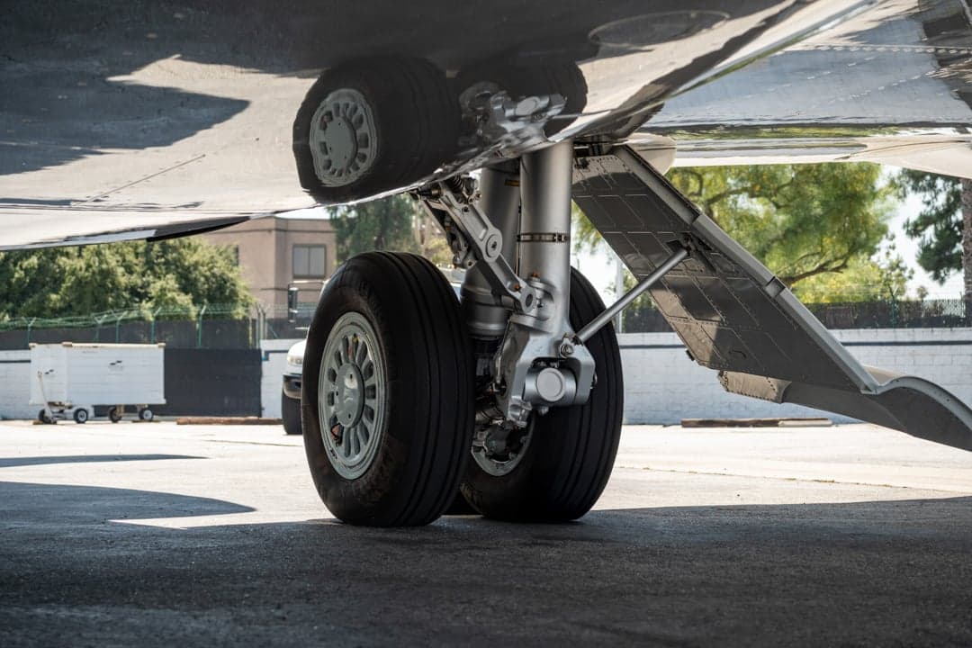 Close up of the landing gear of the white aircraft.