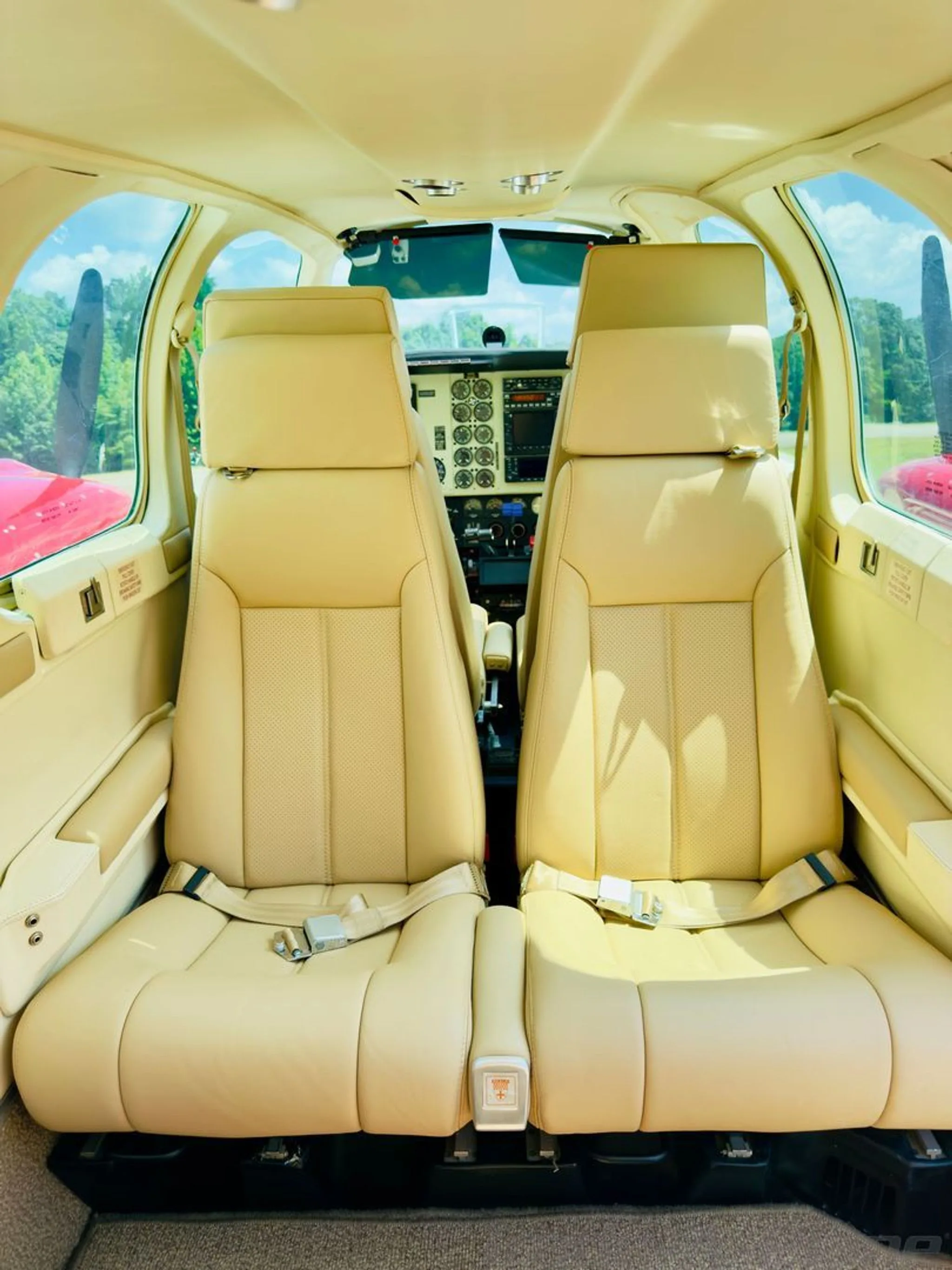 View from the rear cabin looking forward, showing the beige leather seats and the cockpit in the background.
