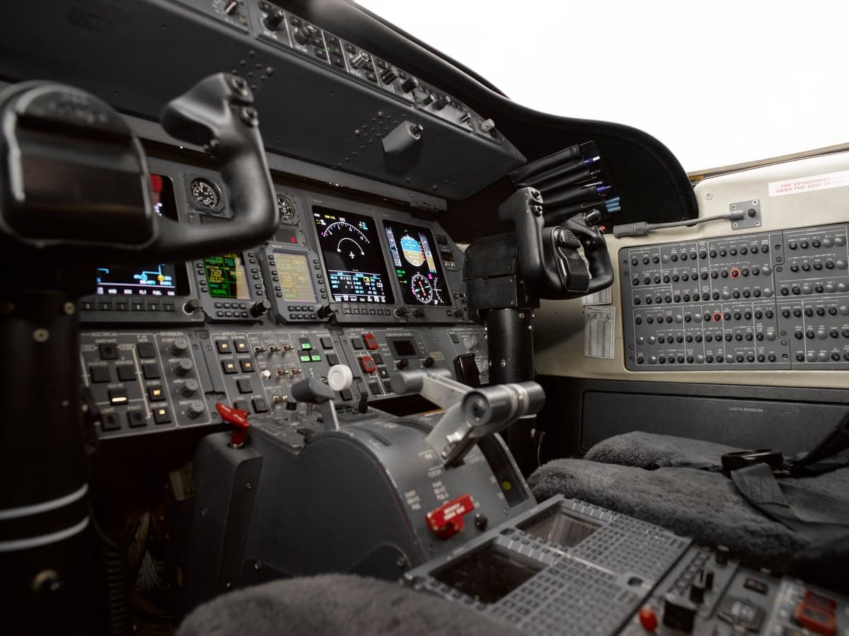 A close-up view of the aircraft cockpit, showing the instrument panel, yokes, and center console.