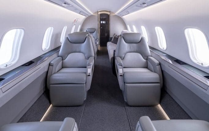 Aircraft interior with leather seats and a world map.