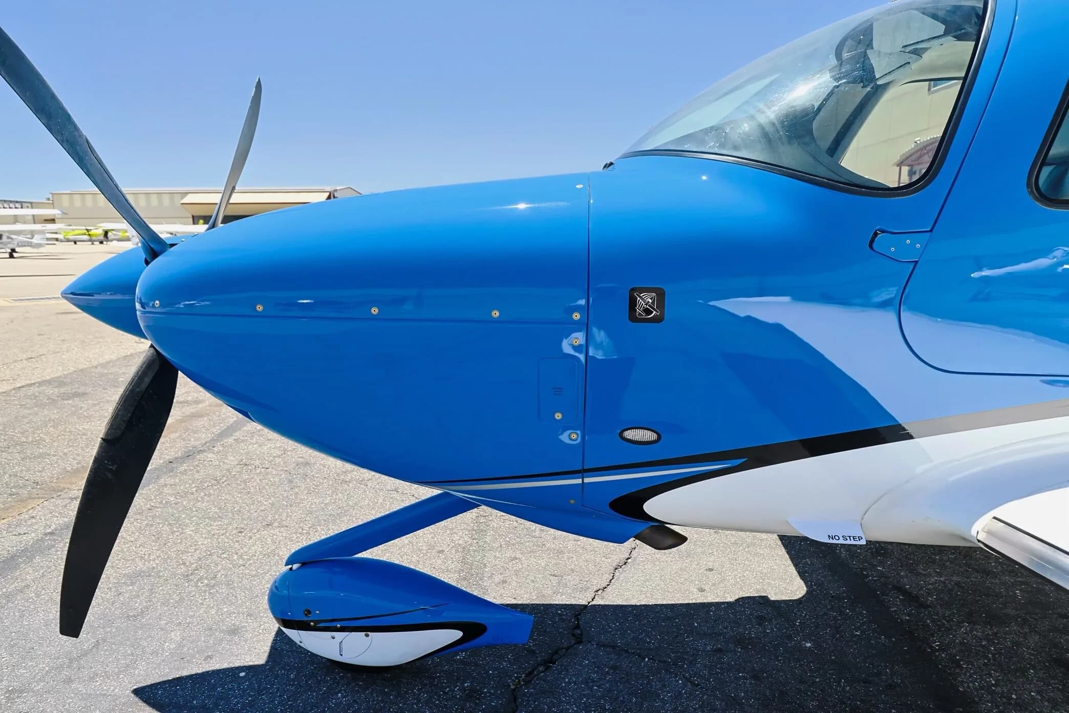 Close-up of the blue nose and propeller of a Cirrus SR22 aircraft (N99W).